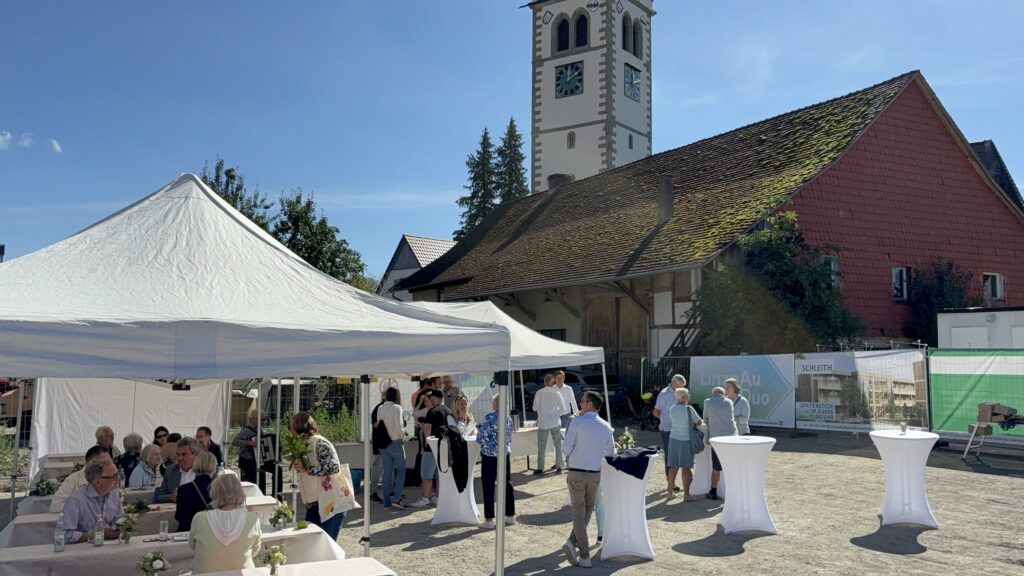 Festzelte und Stehtische beim Spatenstich des LinzgAuDuo in Frickingen vor Kirchturm und historischer Scheune.
